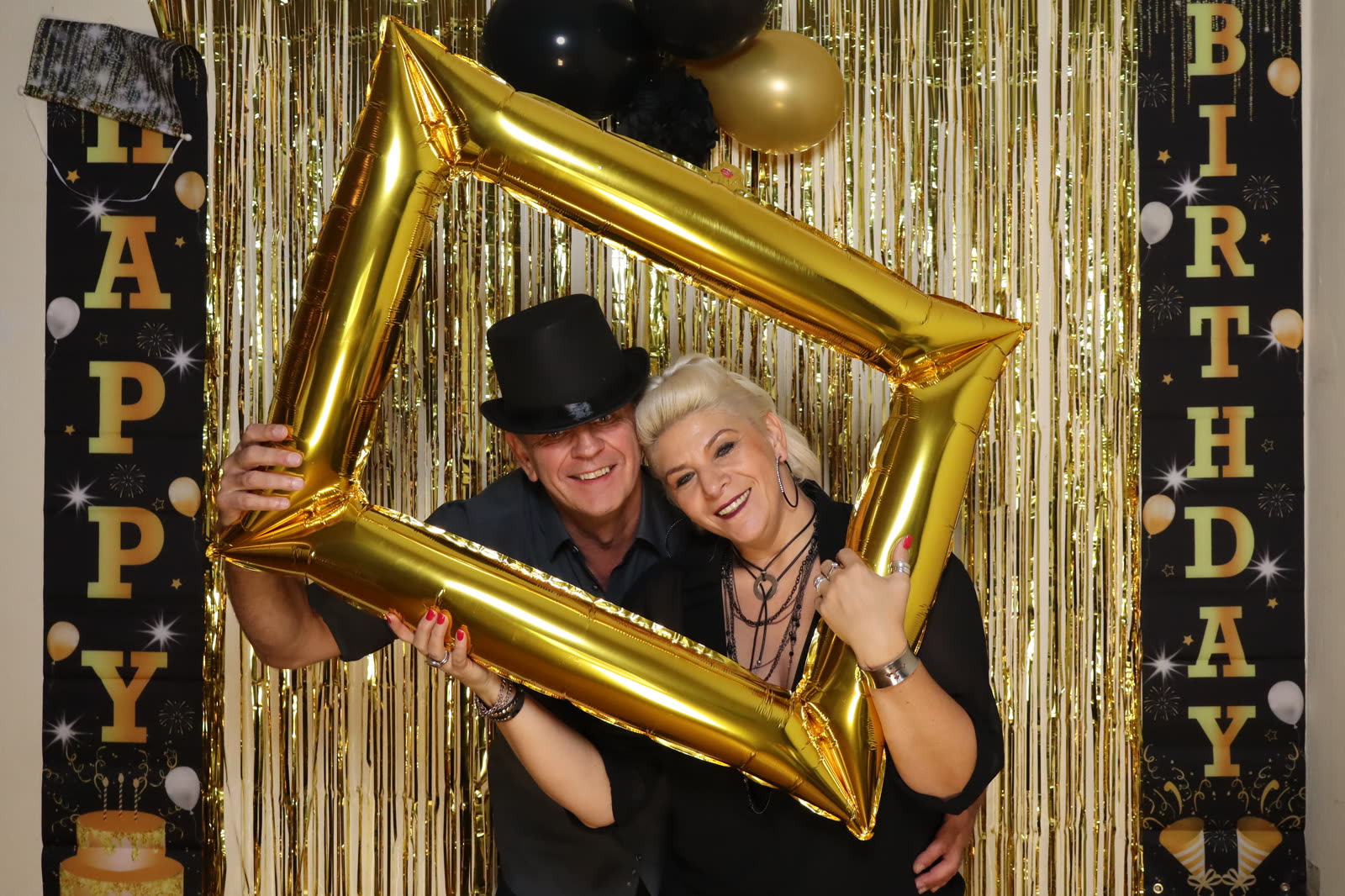 Paar hält einen goldenen Rahmen vor die Kamera der Fotobox